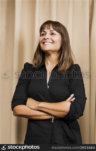 Mature woman standing with her arms crossed and smiling