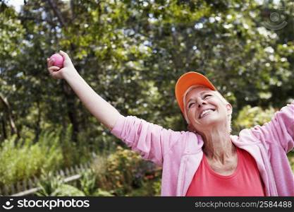 Mature woman standing with her arms outstretched and smiling