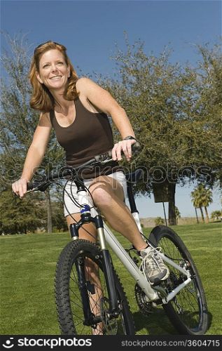 Mature woman stands with mountain bike