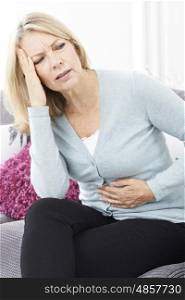 Mature Woman Suffering From Stomach Pain And Headache