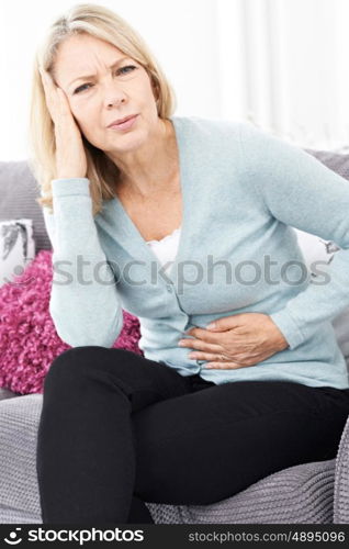 Mature Woman Suffering From Stomach Pain And Headache