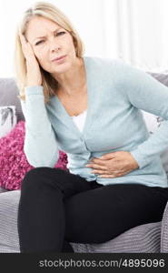 Mature Woman Suffering From Stomach Pain And Headache