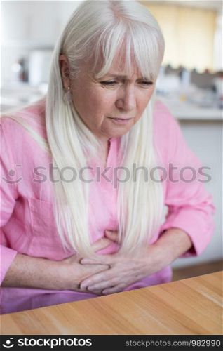 Mature Woman Suffering From Stomach Pain At Home