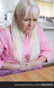 Mature Woman Suffering From Stomach Pain At Home