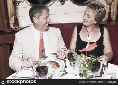 Mature woman taking food with a senior man and smiling
