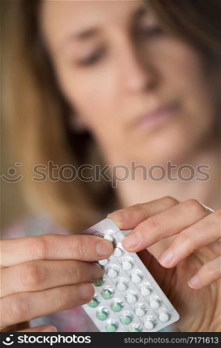 Mature Woman Taking HRT Medication For Symptoms Of Menopause