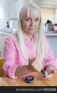 Mature Woman Testing Blood Sugar Level At Home
