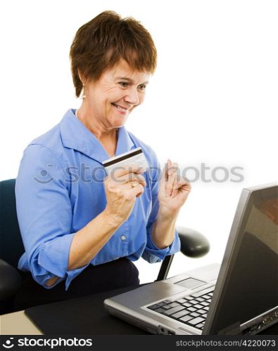 Mature woman uses her credit card to make online purchases from her home office. Isolated on white.