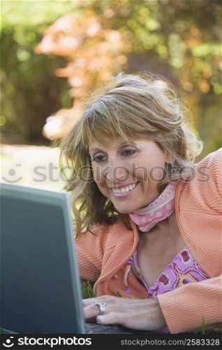 Mature woman using a laptop and smiling