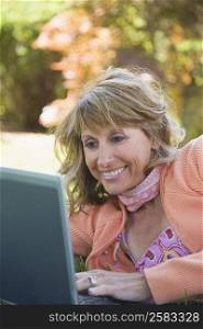 Mature woman using a laptop and smiling