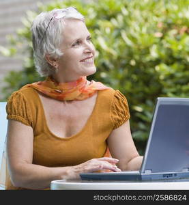 Mature woman using a laptop and smiling