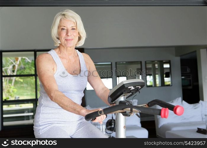 Mature woman using an exercise bike at home
