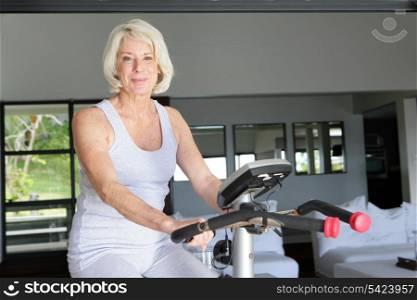 Mature woman using an exercise bike at home