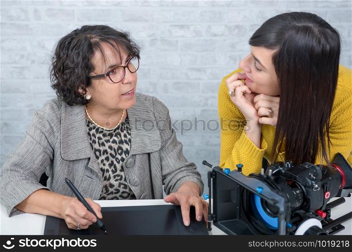 mature woman video editor and young assistant