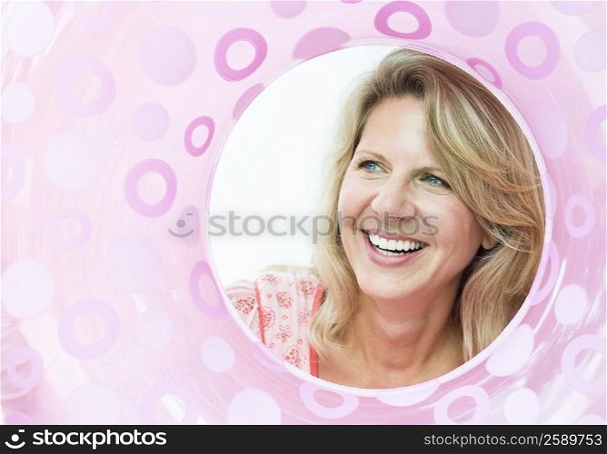 Mature woman viewed through an inflatable ring and smiling
