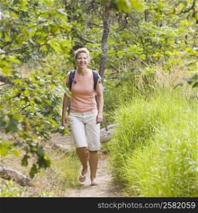 Mature woman walking in a forest and smiling