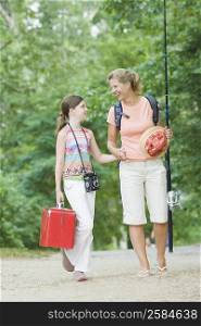 Mature woman walking with holding hands of her daughter