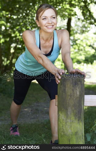 Mature Woman Warming Up Before Exercising In Countryside