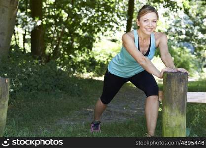 Mature Woman Warming Up Before Exercising In Countryside