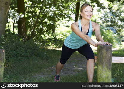 Mature Woman Warming Up Before Exercising In Countryside