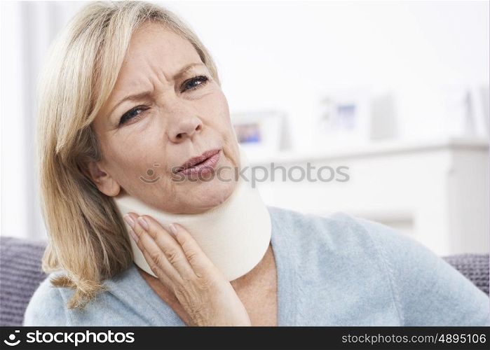 Mature Woman Wearing Surgical Collar In Pain