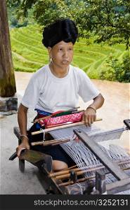 Mature woman weaving a carpet, Jinkeng Terraced Field, Guangxi Province, China