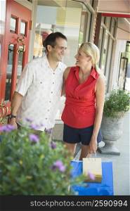 Mature woman with a mid adult man holding shopping bags and smiling
