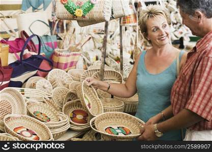 Mature woman with a senior man looking at each other and holding wicker baskets