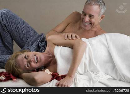 Mature woman with a senior man lying on a massage table and smiling
