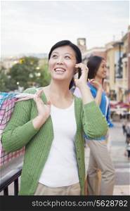 Mature Woman With Cell Phone In Shopping Mall