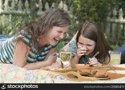 Mature woman with her daughter having picnic in a park