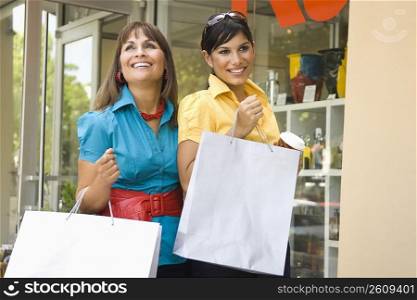 Mature woman with her daughter holding shopping bags and smiling