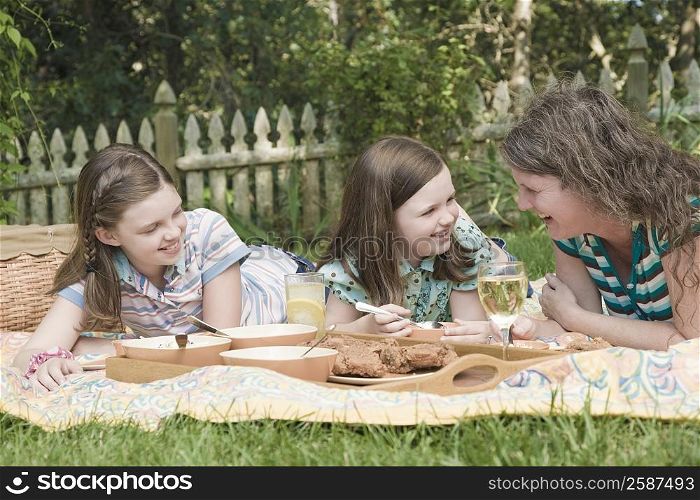 Mature woman with her two daughters having picnic