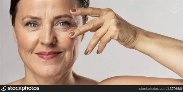 mature woman with make up posing with hand face showing off nails