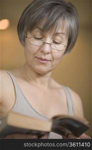 Mature woman with short grey hair reading