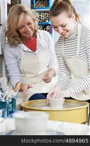 Mature Woman With Teacher In Pottery Class