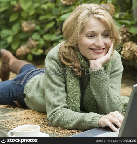 Mature woman working on a laptop and smiling
