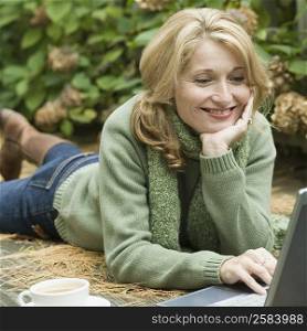 Mature woman working on a laptop and smiling
