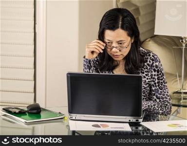 Mature women checking data on her computer while working from home