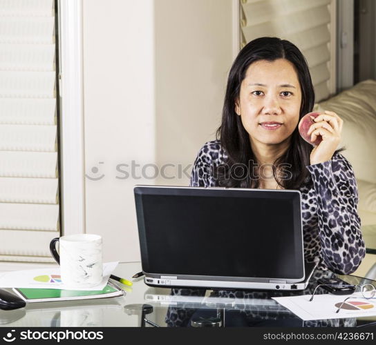 Mature women having snack while at work in home office