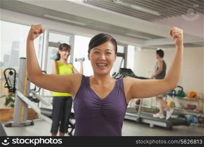 Mature women showing her strength after workout in the gym