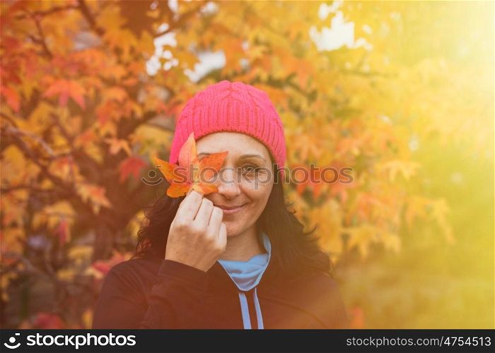 Matured woman with pink wool hat in the forest