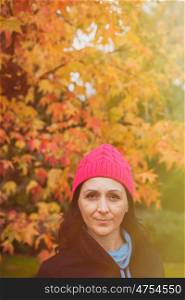 Matured woman with pink wool hat in the forest