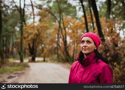 Matured woman with wool pink hat in the forest