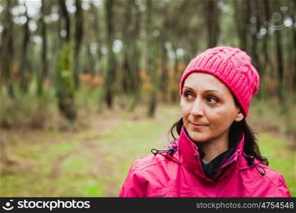Matured woman with wool pink hat in the forest