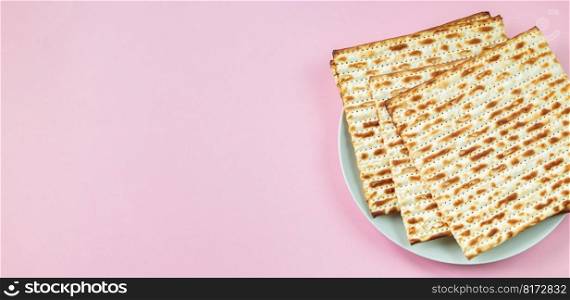 Matzo on pink background. Traditional Jewish food for regilious spring holiday of Pesach. Happy Passover. Copy space, banner format. Matzo on a pink background. Traditional Jewish food for regilious spring holiday of Pesach. Happy Passover. Copy space.