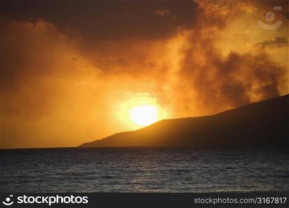 Maui, Hawaii sunset with ocean and island mountain on Maui, Hawaii.