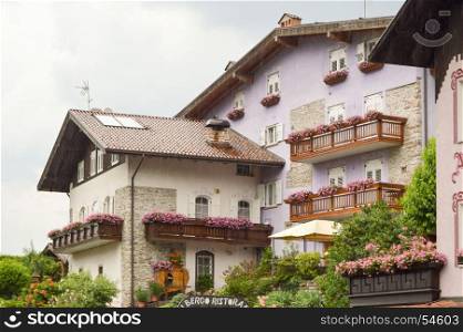 Mauve colored building. Mauve colored building with several balconies flourished in the dolomites in Italy