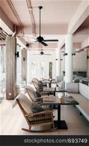 MAY 21, 2014 Krabi, THAILAND - Asian luxury style hotel restaurant with contemporary wooden furnitures, rocking chairs, tables , pillows and minimal decoration