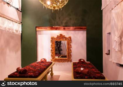 MAY 22, 2014 Koh Lanta, Krabi, Thailand - Modern vintage spa room interior with colorful furnitures, spa beds, louis style mirror frame and chandelier. Modern classic interior design